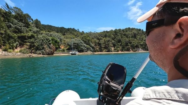 In this image, Adam is rowing us away from Smokehouse Bay in our dinghy. It's a beautiful sunny day and the view from the dinghy shows all of Smokehouse Bay's onshore facilities being used.